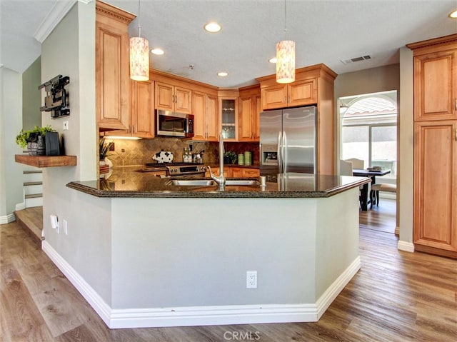 25547 Palermo Way, Yorba Linda, CA 92887 - kitchen featuring appliances with stainless steel finishes, light wood-style floors, a peninsula, recessed lighting, and decorative backsplash
