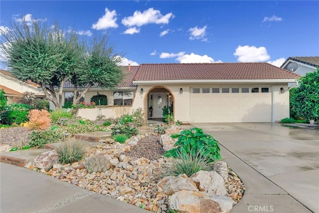 view of front of home featuring stucco siding, a garage, concrete driveway, and a tile roof