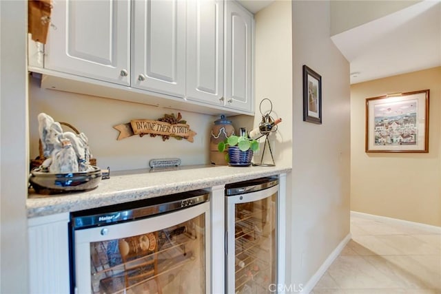 bar featuring wine cooler, a dry bar, baseboards, and light tile patterned flooring