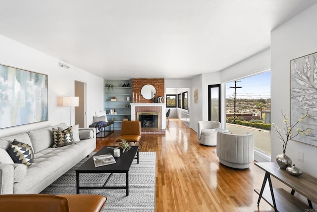 living room featuring visible vents, wood finished floors, and a fireplace