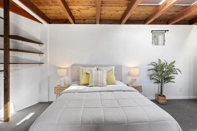 bedroom featuring beamed ceiling, wooden ceiling, baseboards, and carpet floors