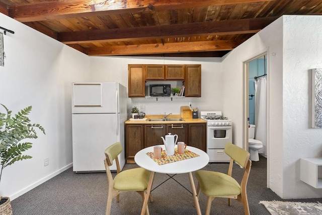 kitchen with beam ceiling, white appliances, wooden ceiling, and a sink