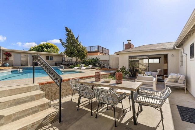 view of pool featuring a patio area, a fenced in pool, and an outdoor hangout area