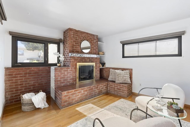 living room with wood finished floors, a fireplace, baseboards, and a healthy amount of sunlight