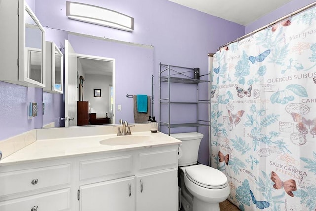 full bathroom featuring a shower with shower curtain, toilet, and vanity