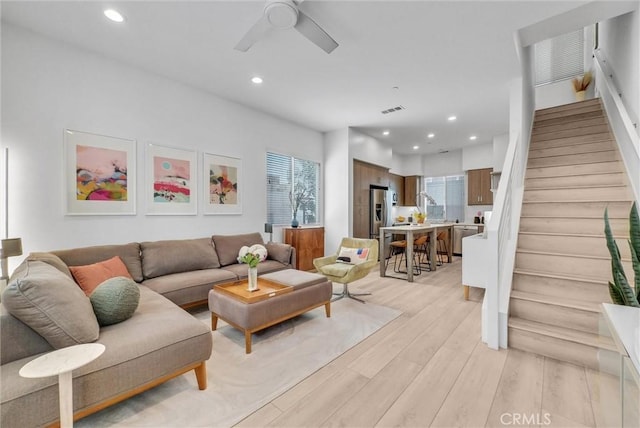 living area with visible vents, recessed lighting, stairs, and light wood-style floors