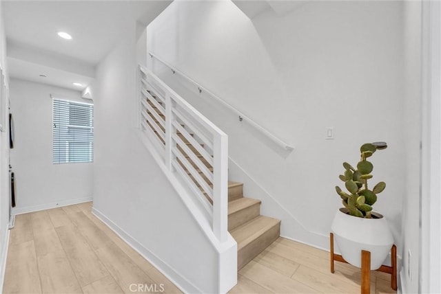 staircase featuring recessed lighting, wood finished floors, and baseboards