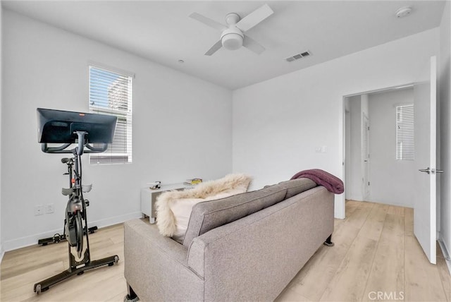 living area featuring visible vents, ceiling fan, baseboards, and light wood-style floors