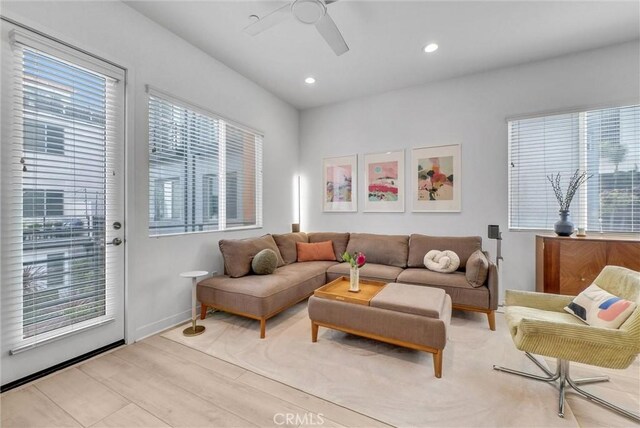 living area with wood finished floors, recessed lighting, a ceiling fan, and baseboards