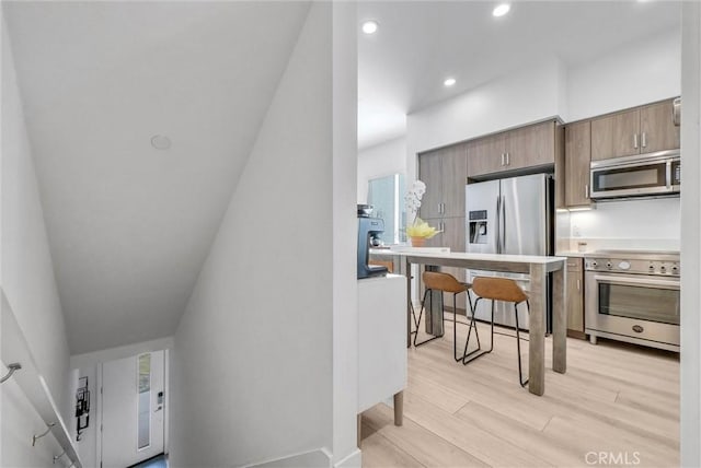 kitchen with recessed lighting, light wood-type flooring, appliances with stainless steel finishes, and light countertops