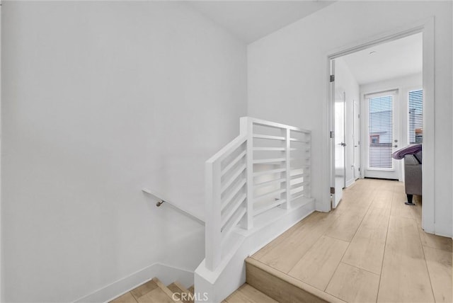 staircase with baseboards and wood finished floors