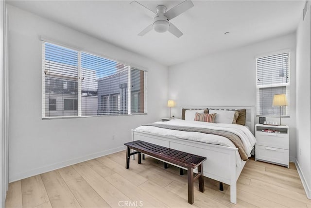 bedroom with light wood-style flooring, baseboards, and ceiling fan