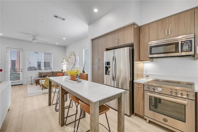 kitchen with visible vents, open floor plan, light wood-type flooring, recessed lighting, and stainless steel appliances