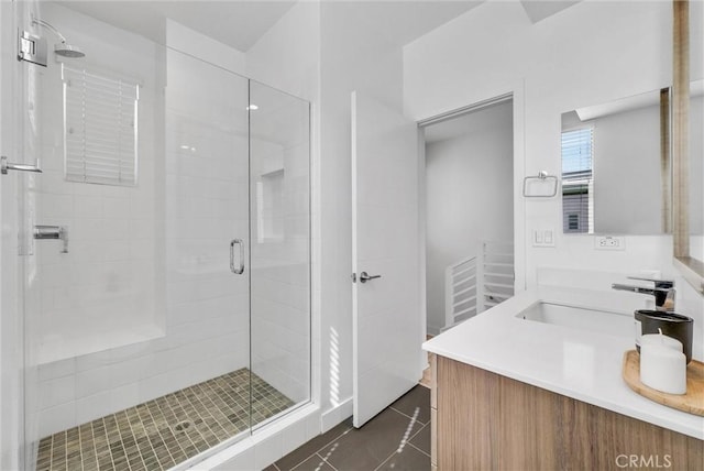 bathroom with tile patterned floors, a shower stall, and vanity