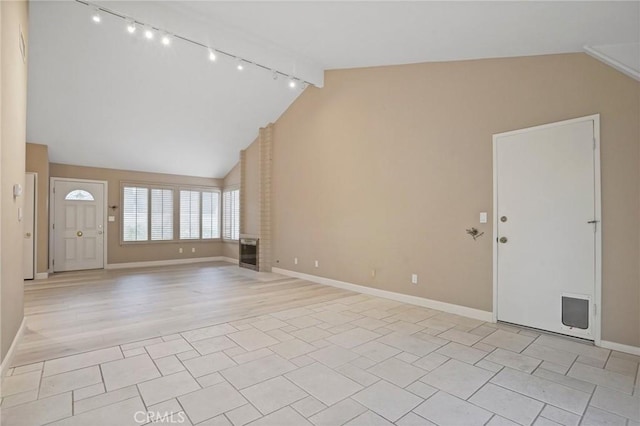 unfurnished living room featuring light wood-style flooring, baseboards, and high vaulted ceiling