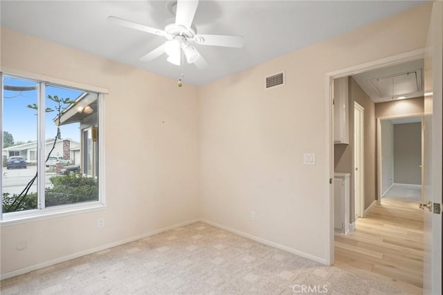 empty room with attic access, baseboards, visible vents, and a wealth of natural light