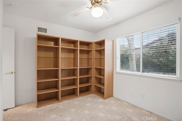 interior space with visible vents and ceiling fan