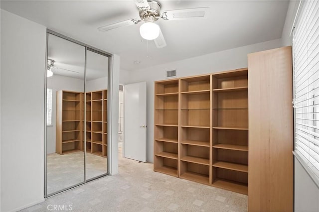 unfurnished bedroom with a closet, visible vents, ceiling fan, and carpet floors