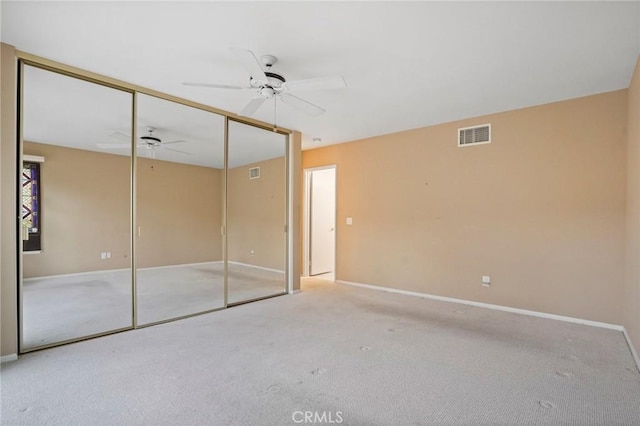 unfurnished bedroom featuring baseboards, visible vents, carpet floors, ceiling fan, and a closet