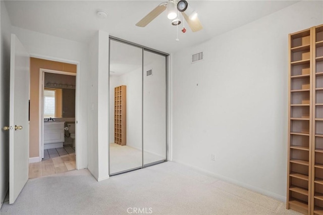 unfurnished bedroom featuring visible vents, carpet, a closet, and ceiling fan