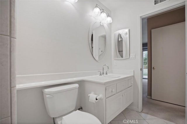 bathroom with visible vents, toilet, vanity, and tile patterned flooring