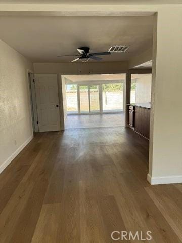 hall featuring visible vents, baseboards, and wood finished floors