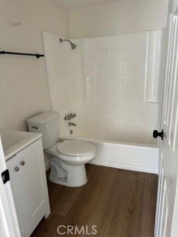 bathroom with toilet, vanity, shower / bathing tub combination, and wood finished floors