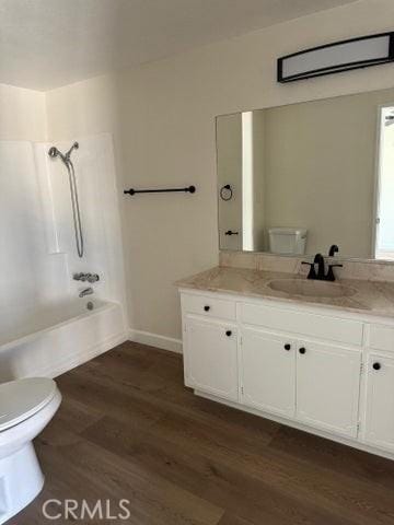 full bath featuring tub / shower combination, baseboards, toilet, wood finished floors, and vanity