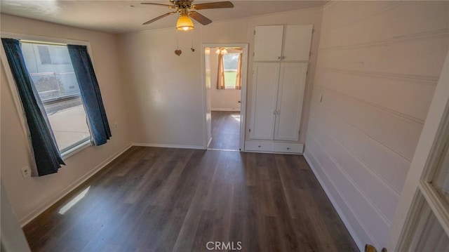 spare room featuring dark wood finished floors, baseboards, and ceiling fan