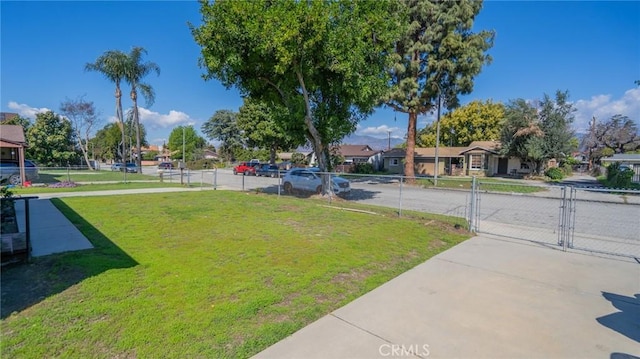 exterior space featuring a residential view, fence, and a gate