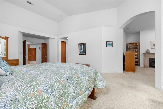 bedroom with visible vents, arched walkways, carpet floors, baseboards, and high vaulted ceiling