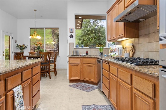 kitchen with backsplash, under cabinet range hood, light stone countertops, and stainless steel gas stovetop