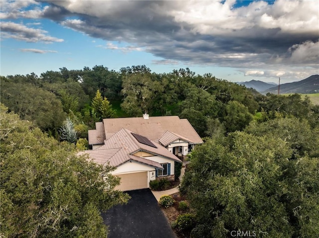 aerial view featuring a wooded view and a mountain view