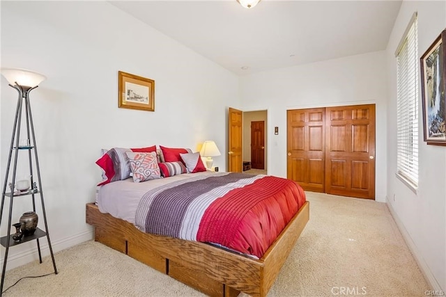 carpeted bedroom with a closet and baseboards
