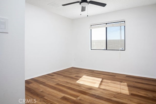 unfurnished room featuring ceiling fan, a textured ceiling, baseboards, and wood finished floors