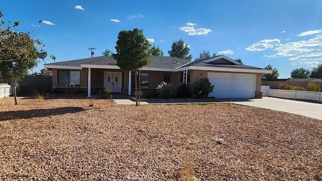 ranch-style house featuring a garage, driveway, and fence