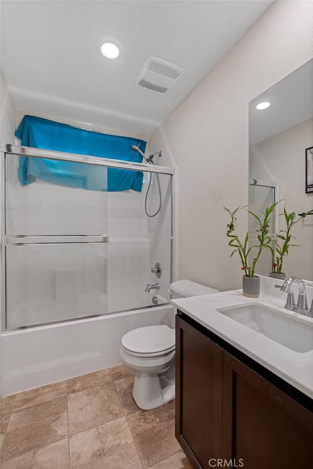 full bath with visible vents, enclosed tub / shower combo, toilet, and vanity