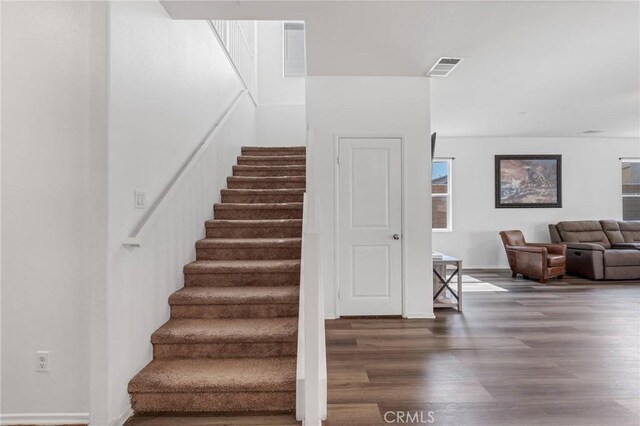 stairs with visible vents and wood finished floors