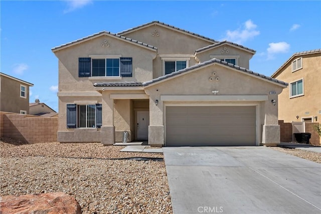 view of front facade with concrete driveway, an attached garage, fence, and stucco siding