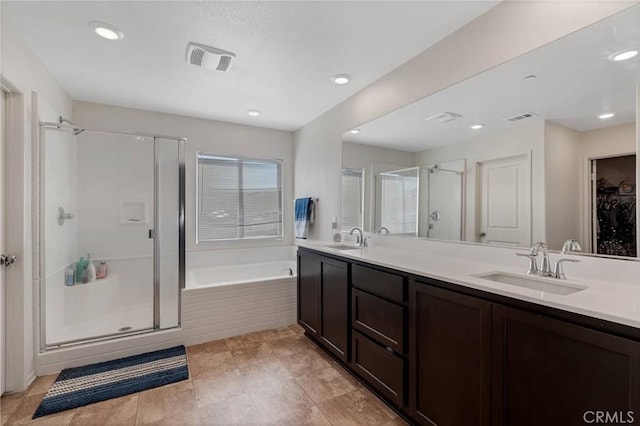 bathroom featuring a shower stall, a bath, visible vents, and a sink