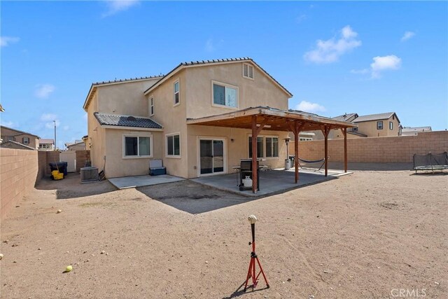 back of property featuring a patio area, a fenced backyard, stucco siding, and a trampoline