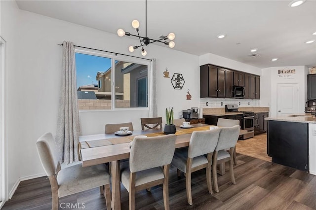 dining area with recessed lighting, baseboards, a notable chandelier, and dark wood-style flooring