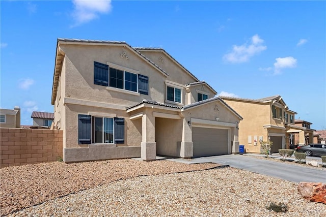 traditional-style house with stucco siding, driveway, a garage, and fence