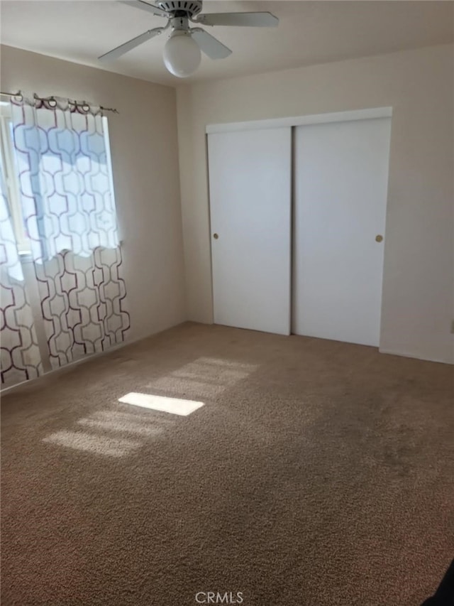 unfurnished bedroom with carpet flooring, a closet, and ceiling fan