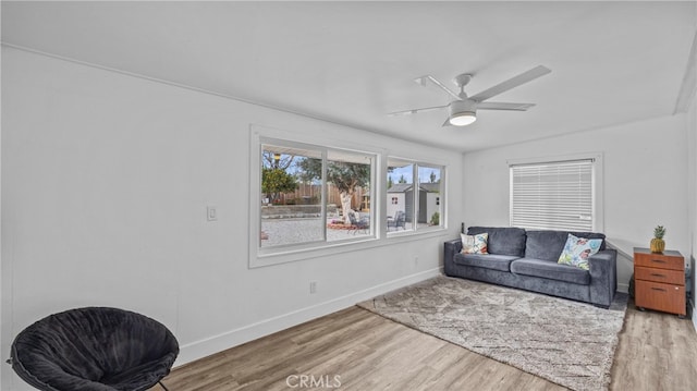 interior space with a ceiling fan, wood finished floors, and baseboards