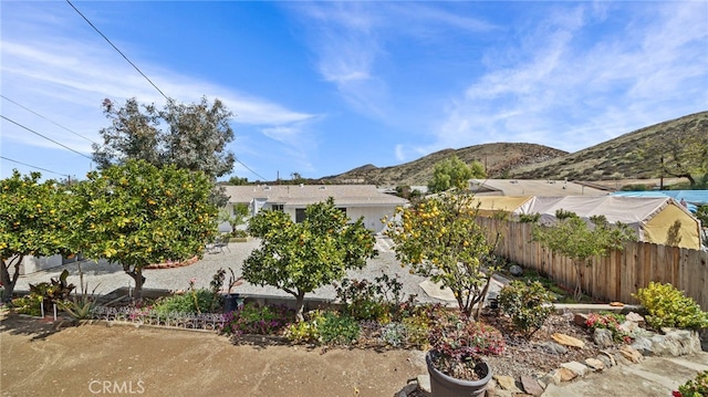 view of yard featuring a mountain view and fence