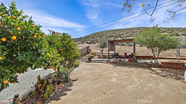 view of patio featuring a mountain view and fence