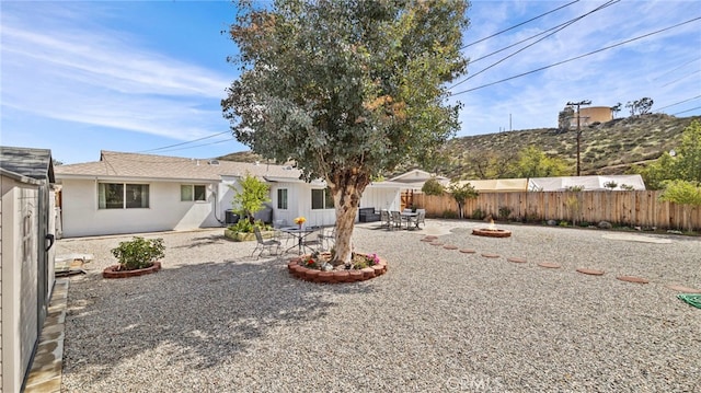 back of house with a fire pit, a patio, and fence