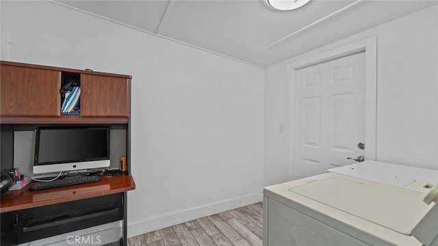 washroom featuring baseboards, washer and clothes dryer, laundry area, and light wood finished floors