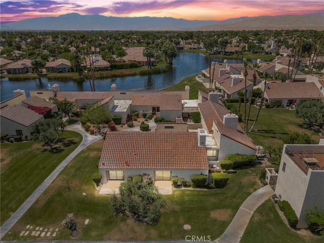 aerial view at dusk featuring a residential view and a water and mountain view